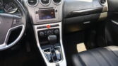 Interior view of a car dashboard showing a center touchscreen, three circular air vents, and the gear shifter surrounded by glossy trim.