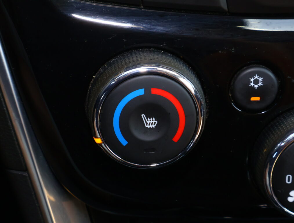 Circular car climate control dial with blue and red segments indicating cool and warm settings, and a heated-seat icon in the center.