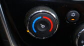 Circular car climate control dial with blue and red segments indicating cool and warm settings, and a heated-seat icon in the center.