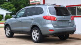 Gray Hyundai SUV parked in front of a white dealership building with red trim.