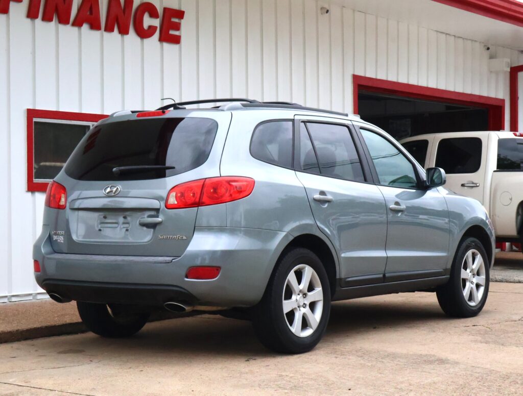 Silver Hyundai Santa Fe parked outside a finance office with white walls and red trim.
