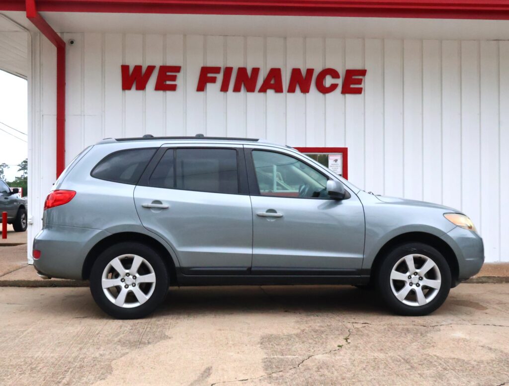 Silver SUV parked in front of a white wall with a bold red 'WE FINANCE' sign above it