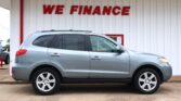 Silver SUV parked in front of a white wall with a bold red 'WE FINANCE' sign above it