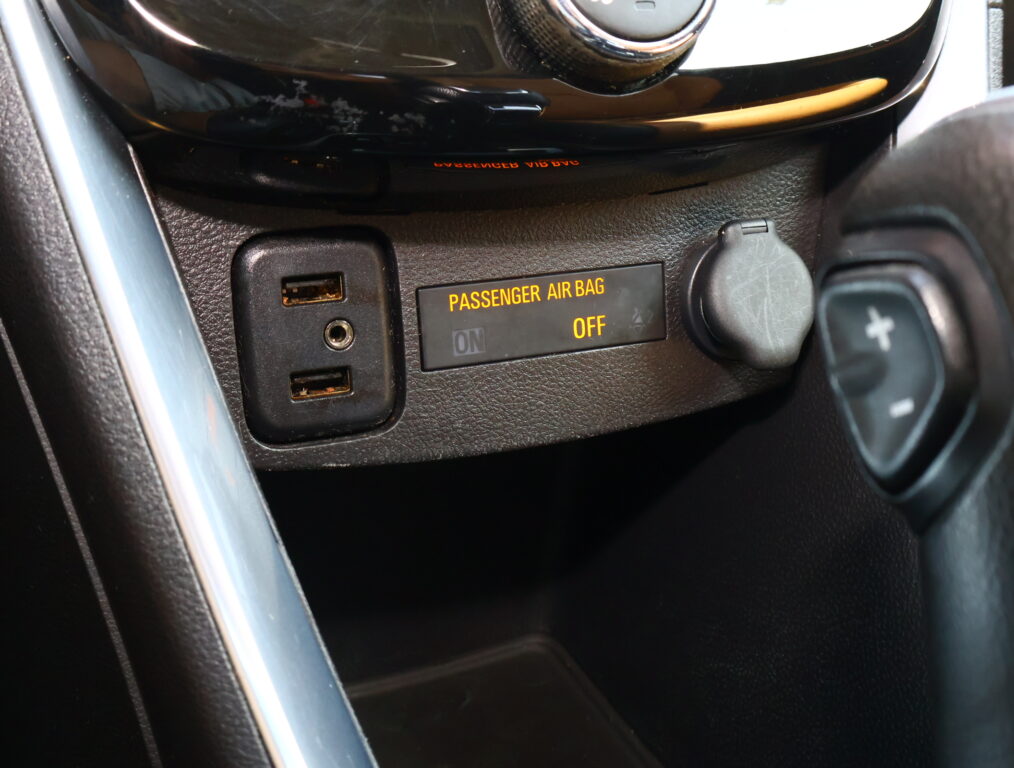 Close-up of car dashboard showing the "PASSENGER AIR BAG OFF" indicator, USB ports, and surrounding console trim.