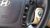 Close-up of a Hyundai steering wheel showing cruise control buttons: ON/OFF, RES/ACCEL, COAST/SET, and CANCEL along the side.