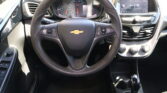 Interior view from the driver seat showing a Chevrolet steering wheel, instrument cluster, and right-side touchscreen display.