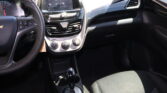 Interior of a car: steering wheel left, central touchscreen display, climate controls, and gear shifter in view.