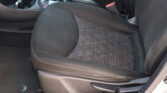 Front seats and center console of a car, with the gear shifter, cup holders, and seat belt buckles visible in a dark interior.