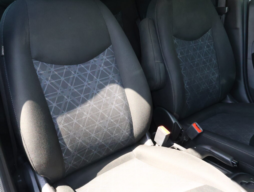 Front car seats with dark fabric upholstery and a geometric patterned center panels in gray and black tones.