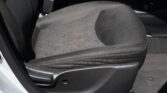 Dark fabric car seat with a red-trimmed seatbelt buckle visible beside it.