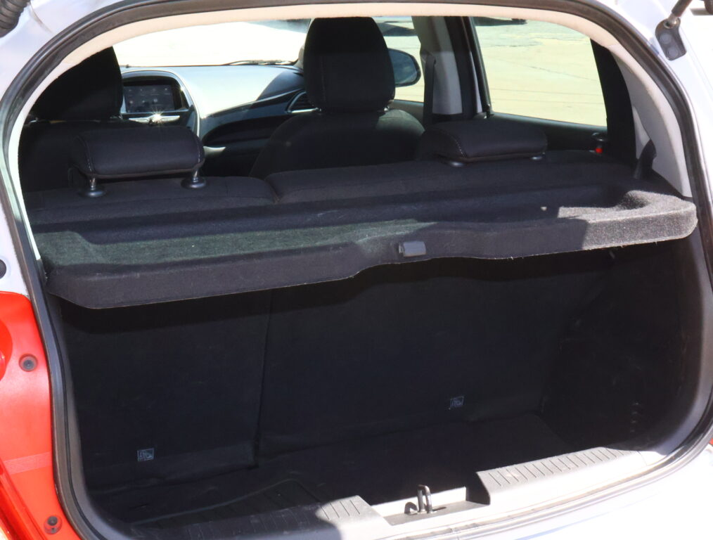 Open hatchback trunk with a large flat cargo area formed by folded rear seats and black upholstery in the interior.