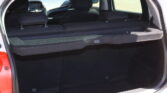 Open hatchback trunk with a large flat cargo area formed by folded rear seats and black upholstery in the interior.