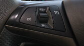 Close-up of a car steering wheel's cruise control panel showing RES/+ and SET/- buttons.