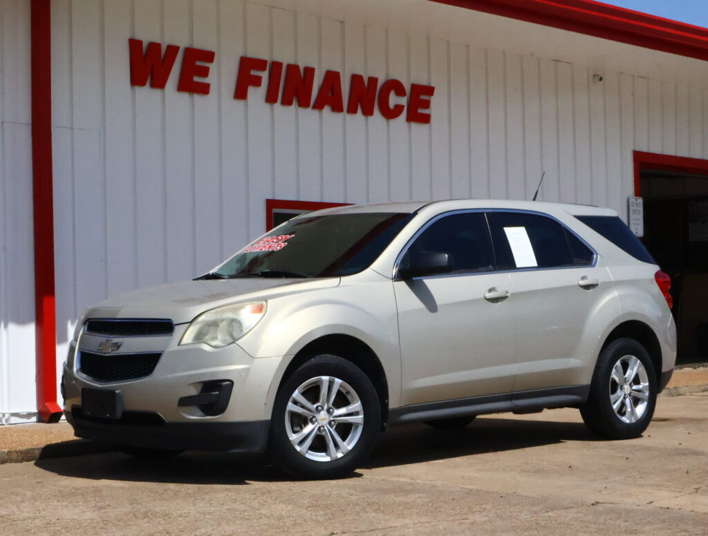 White SUV parked in front of a white wall with red trim and a bold 'WE FINANCE' sign above it.