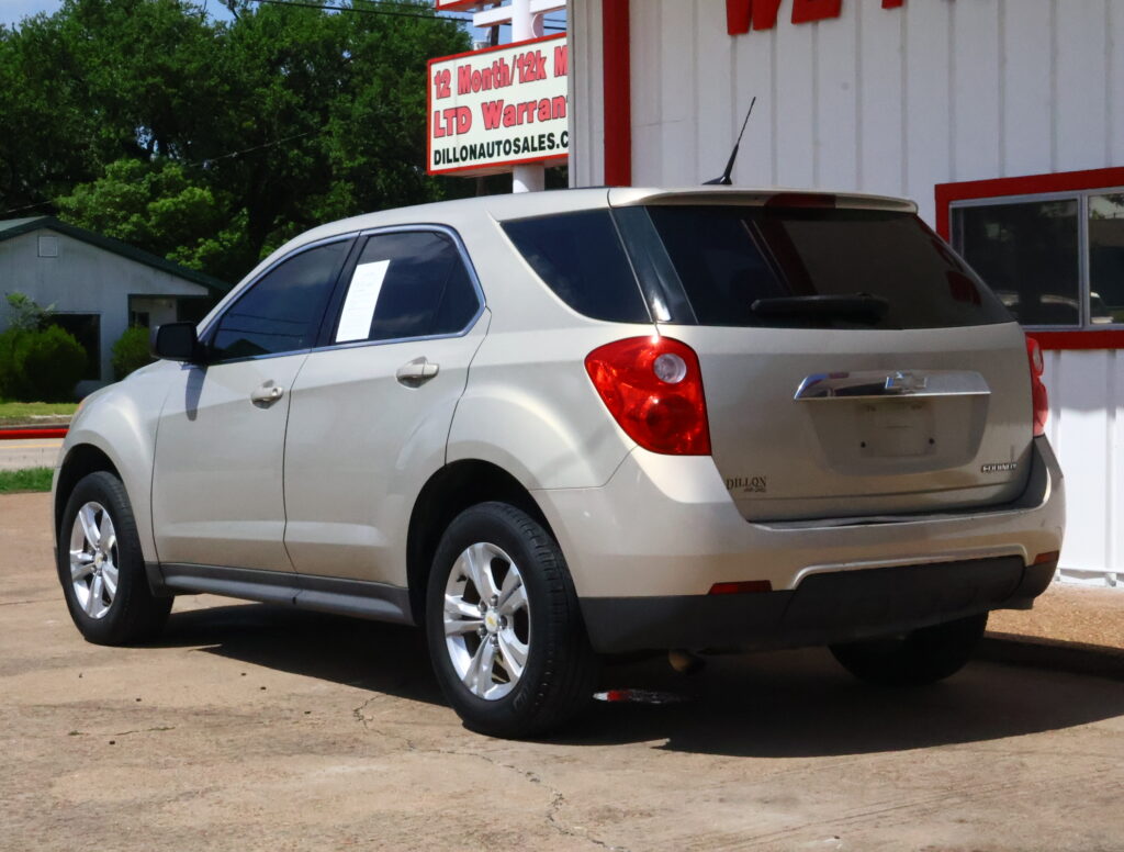 Silver SUV parked outside a dealership with a red-and-white Dillon Auto sign in the background.
