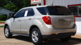 Silver SUV parked outside a dealership with a red-and-white Dillon Auto sign in the background.