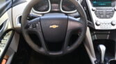 Close-up view of a Chevrolet steering wheel inside a car, with the speedometer and center console in view.