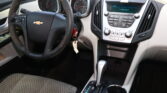Interior of a Chevrolet: steering wheel, dashboard gauges, and center console with gear shifter.