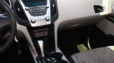 Interior of a car showing the center console with gear shifter, cup holders, and control panel buttons.
