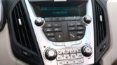 Car dashboard center console with radio controls and a digital display showing 2:10 and the date 11/06/2010, surrounded by buttons and climate controls.