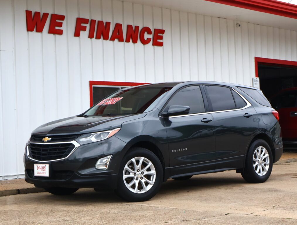 Gray Chevrolet Equinox parked in front of a white building with red 'WE FINANCE' lettering.