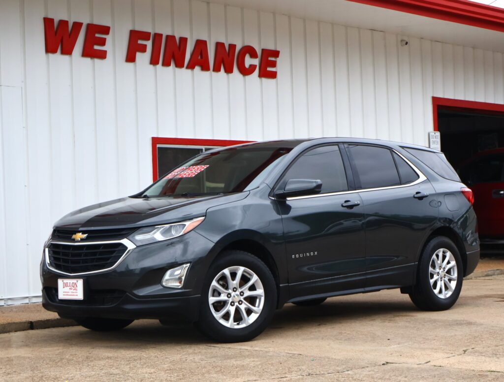Gray Chevrolet Equinox parked in front of a white building with red 'WE FINANCE' lettering.