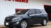Gray Chevrolet Equinox parked in front of a white building with red 'WE FINANCE' lettering.