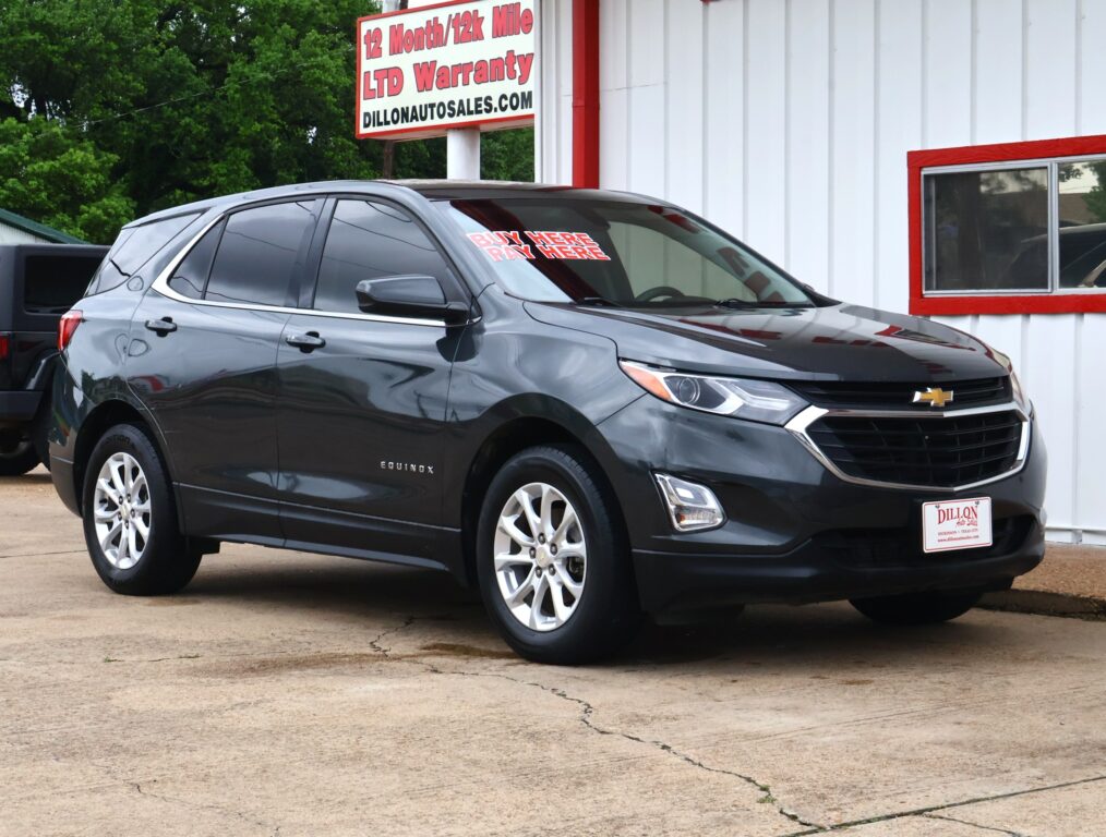 Dark gray Chevrolet Equinox SUV parked in front of a white building with red trim and a Dillon Auto Sales sign