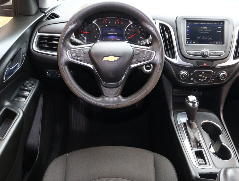 Steering wheel with Chevy logo, digital instrument cluster, and center infotainment screen in a SUV interior.