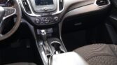 Interior of a car cabin focusing on the center console with a touchscreen display and gear lever area