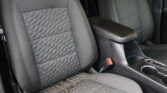 Front car seats with black quilted fabric and orange stitching, center armrest between them