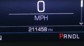 Vehicle dashboard showing 0 MPH speed with odometer reading 211,458 miles and PRNDL gear selector visible