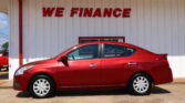 Red car parked in front of a white building with red trim and a bold 'WE FINANCE' sign above.