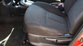 Front passenger seat in a car with a red seat belt buckle visible and the center console nearby.