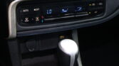 Close-up of a car's climate control panel showing LO temperature and fan icons, with gear shifter in foreground.