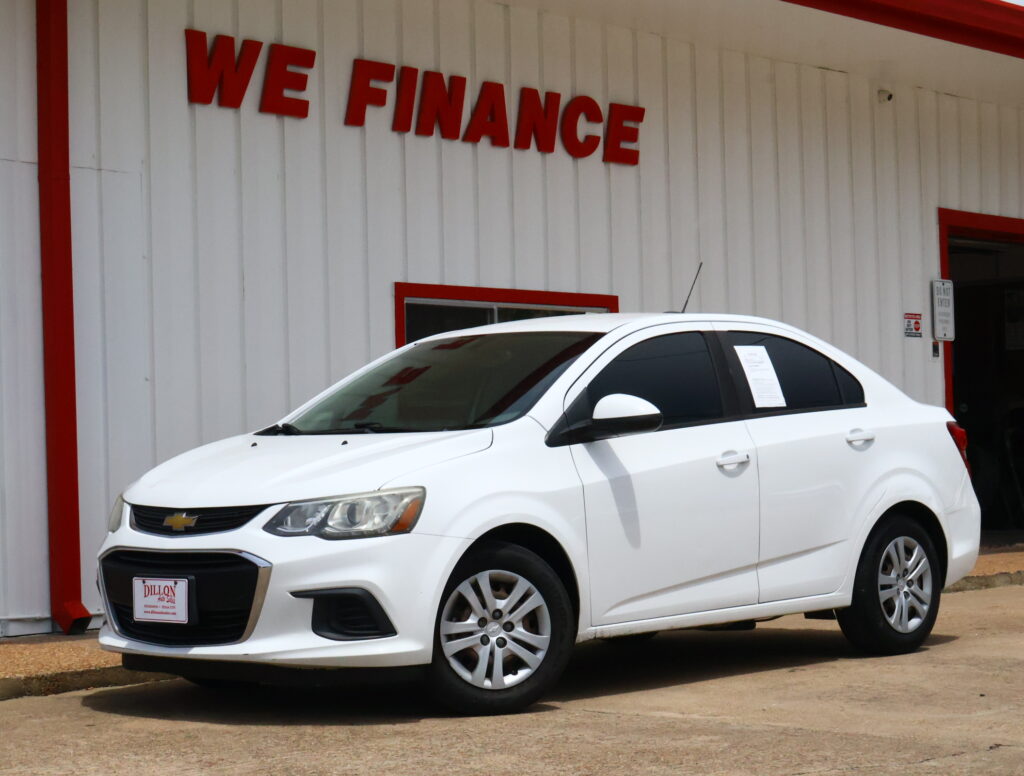 White Chevrolet SUV parked in front of a white building with red trim and a 'WE FINANCE' sign visible above.