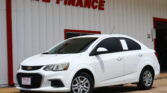 White Chevrolet SUV parked in front of a white building with red trim and a 'WE FINANCE' sign visible above.