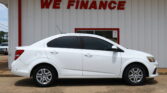 White car parked in front of a light-colored wall with a bold red 'WE FINANCE' sign above.