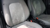 Front and driver seats in a car with grey fabric upholstery and a white dotted pattern.
