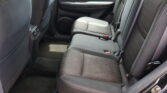Rear passenger area of a car with black fabric seats, door panel, and rear ventilation visible.