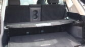 Cargo area of a Nissan Rogue with rear seats folded, black carpeting, and Rogue-branded floor mat visible