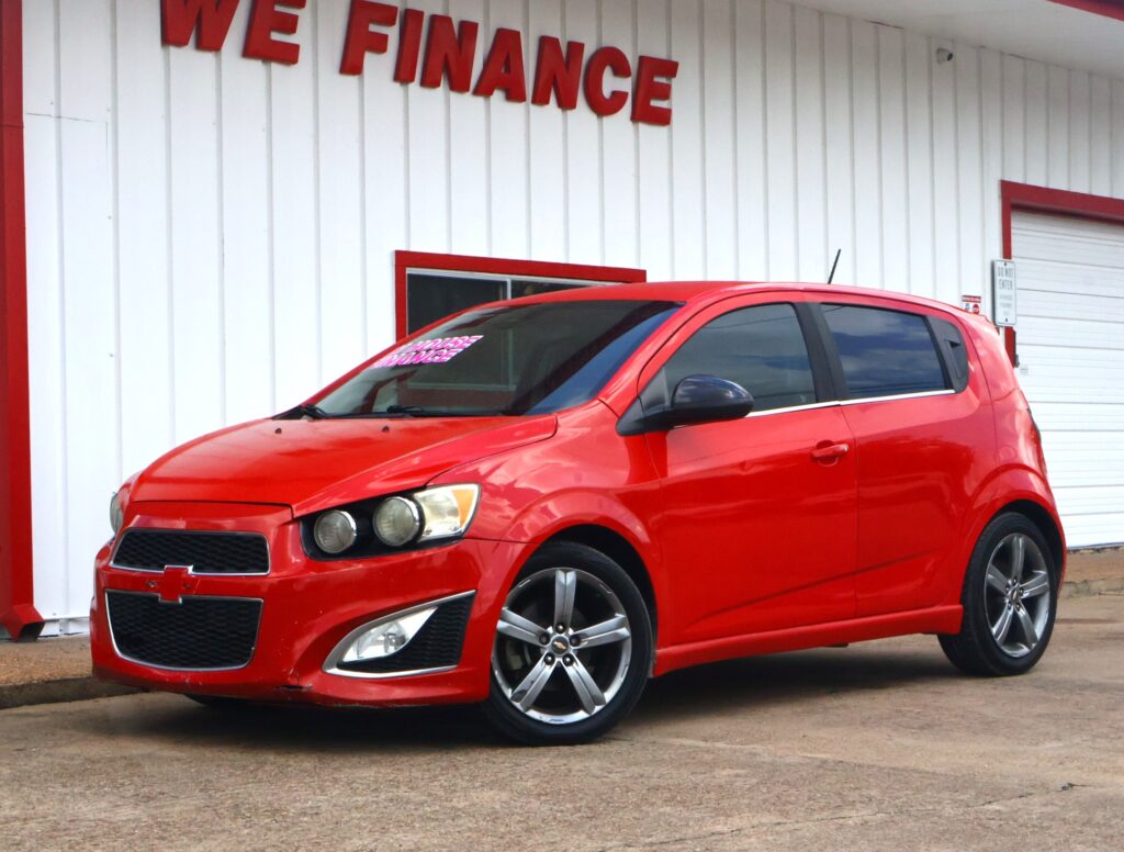 Red car parked in front of a white building with large red 'WE FINANCE' lettering above.