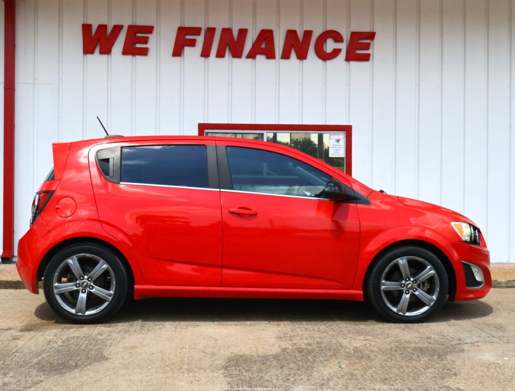 Red SUV parked in front of a white building with a bold red 'WE FINANCE' sign above.