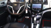 Driver's cockpit with leather-wrapped steering wheel, digital instrument cluster, and glossy center touchscreen in a Chevrolet interior