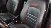 Black leather car seats with red contrast stitching and RS embroidered logos on the headrests, front row interior view.
