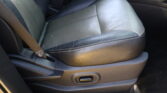 Close-up of a black leather car seat with white stitching and a visible seat belt at the left side.