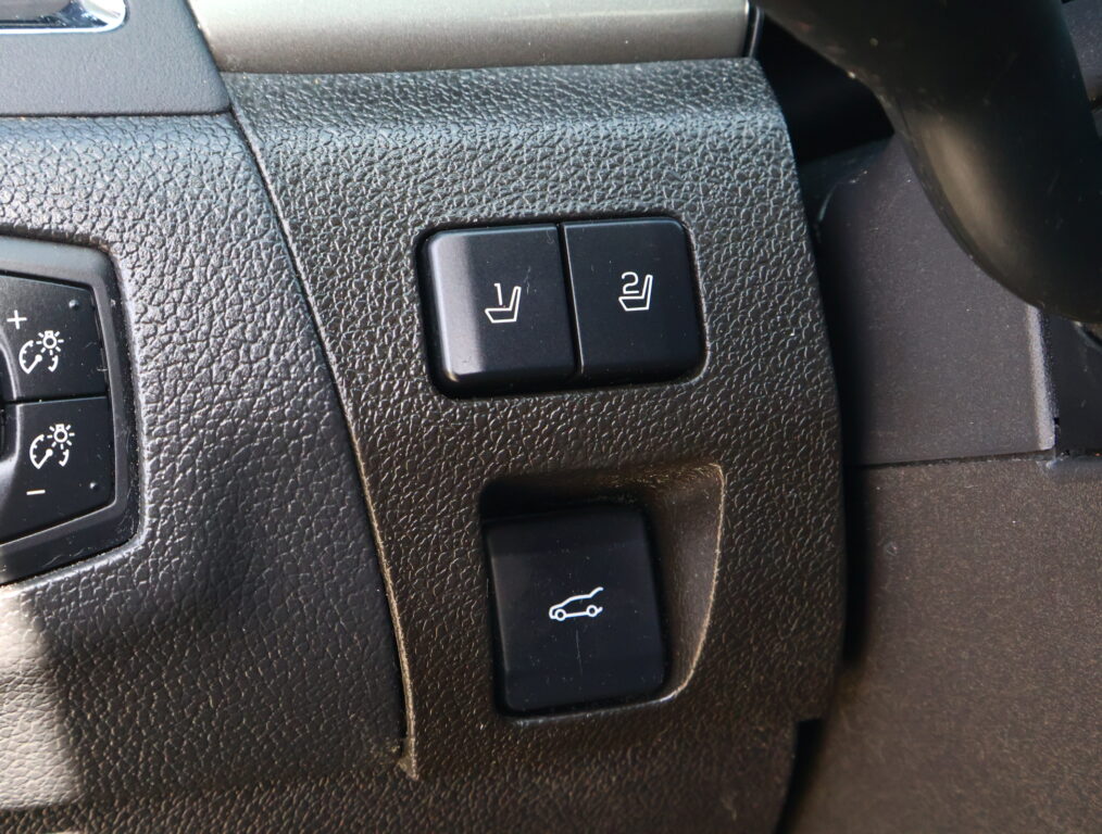 Two heated-seat buttons (1 and 2) on a textured car dashboard for front-seat heating