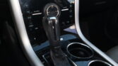 Close-up of a car center console with a leather gear shifter and glossy black control panel labeled SONY and visible drive modes (P R N D).