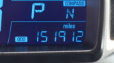 Close-up of a car's digital dashboard showing the COMPASS mode and blue numeric readout.