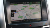 In-dash GPS map showing road names like FM 517 Rd, Hughes Rd, and Highway 3 N on a car's navigation screen